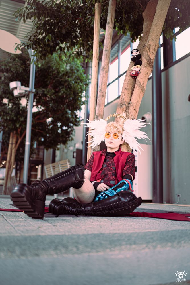 Trigun 98/Maximum inspired Vash the Stampede cosplay, with wings and an aureole. Trigun plushies are stuck in the tree