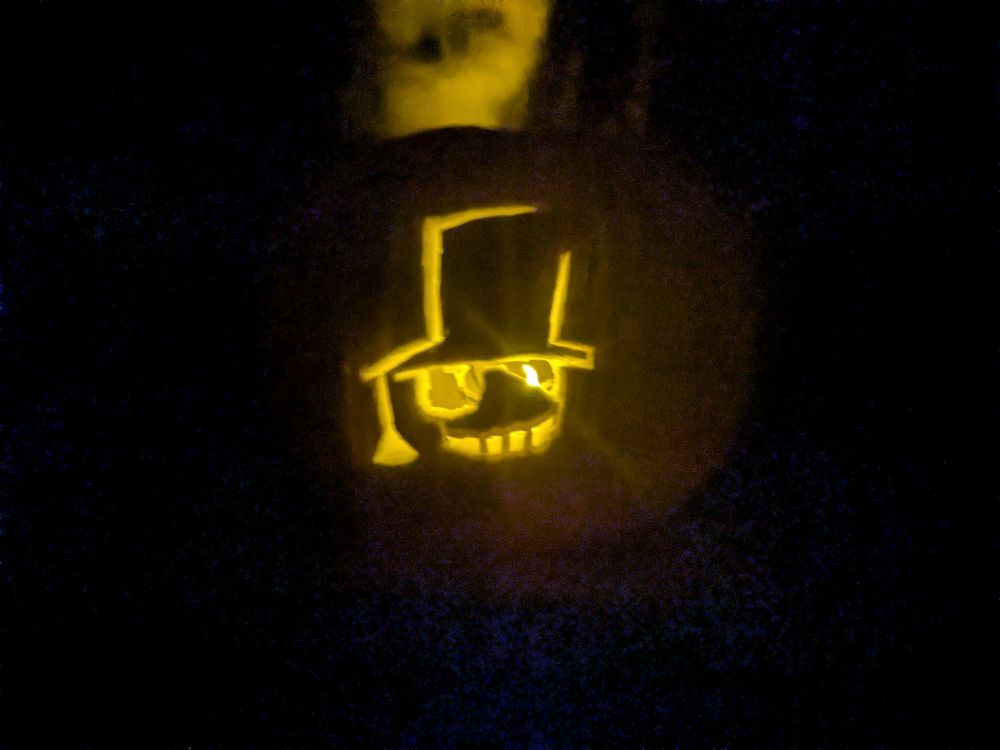 The kaito kid logo on the pumpkin lit up in a dark room 