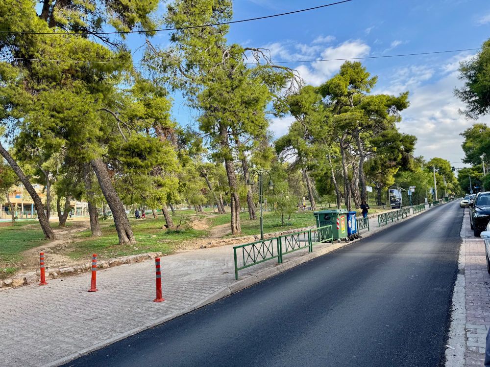 a newly black-topped road next a park