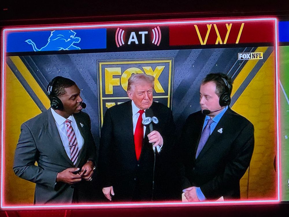 The Asshole-in-Chief is welcomed by sycophantic broadcasters in the booth at the Commanders-Lions game.