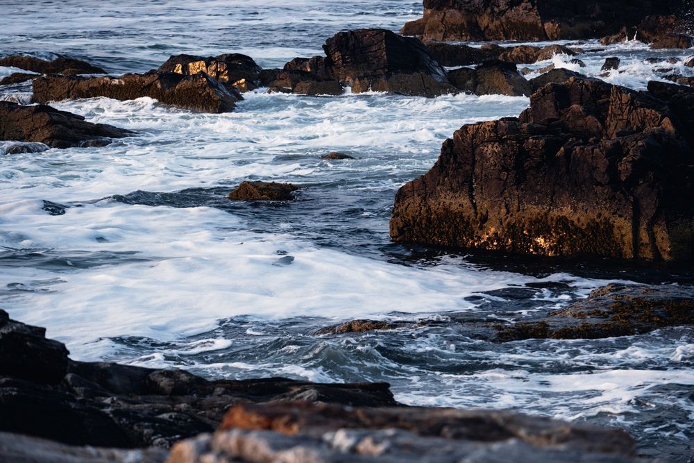 Photo of ocean waves along the rocky coastline.