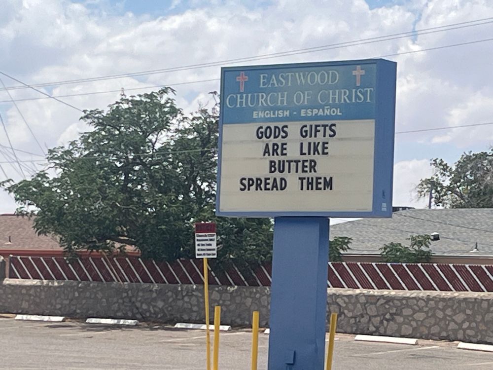 A streetside message-board sign for Eastwood Church of Christ, printed with the phrase GODS GIFTS ARE LIKE BUTTER SPREAD THEM