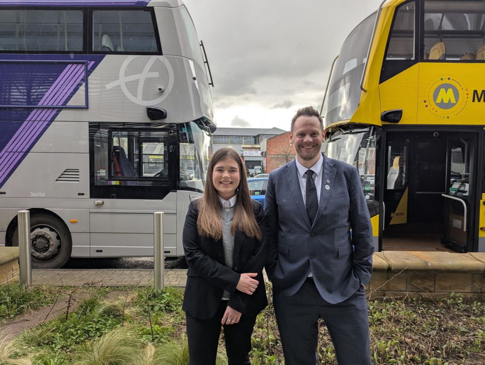 UTG Policy Advisor Monta Drozdova and Local Transport Minister Simon Lightwood, with two buses in the background, in Sheffield.