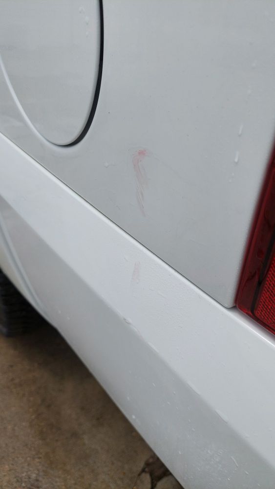 Rear quarter panel picture showing red smudges on white paint where someone rammed a shopping cart into the side of the truck.