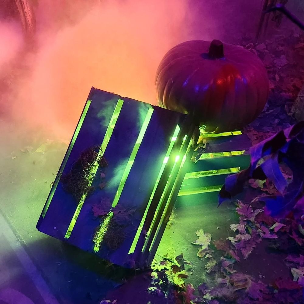 A couple of glowing boxes next to a pumpkin.