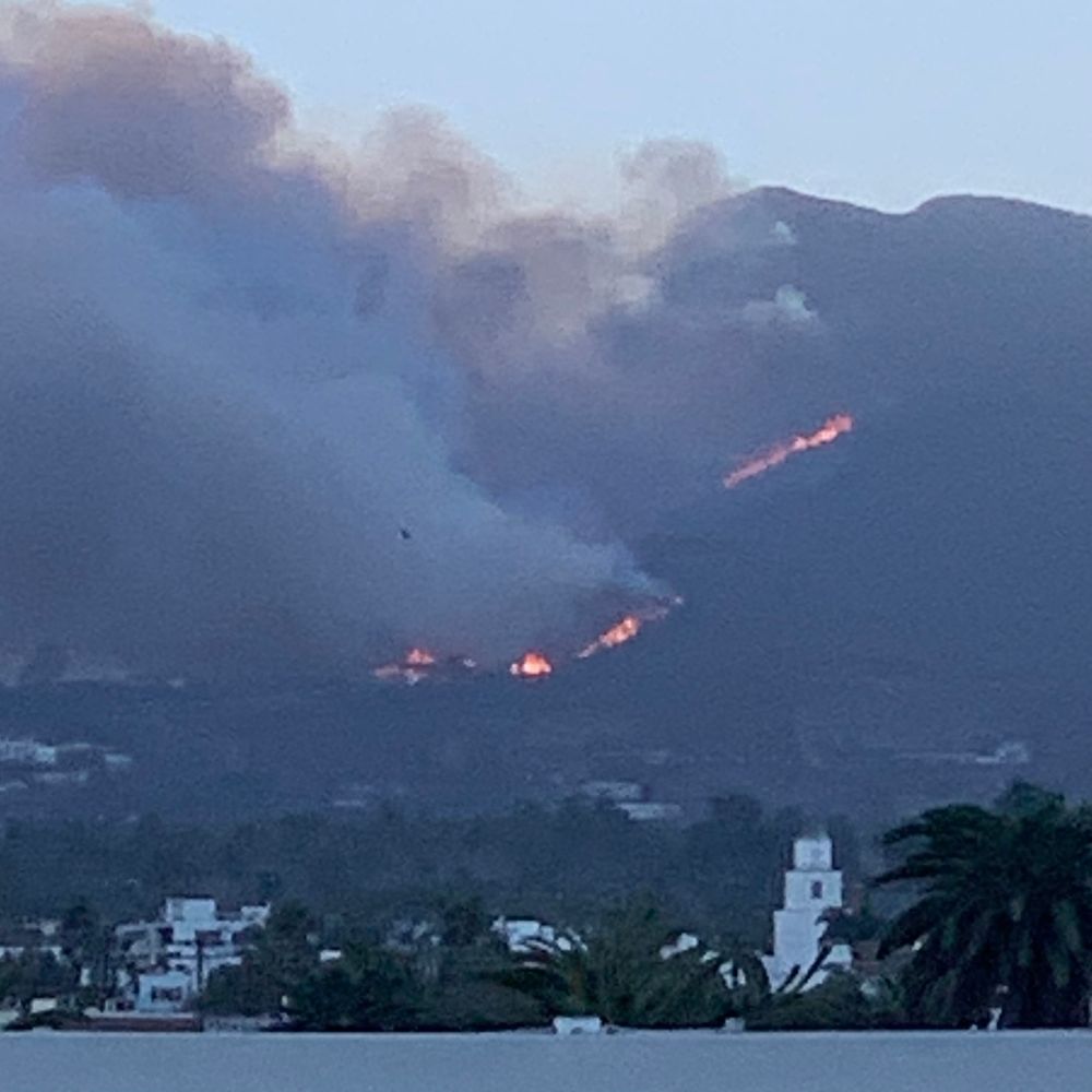 A line of glowing orange wildfire chewing up the hillside.