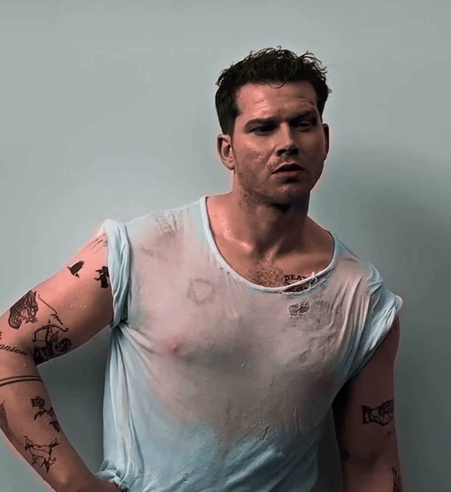 oliver stark in soaked-through white shirt with tons of tattoos visible