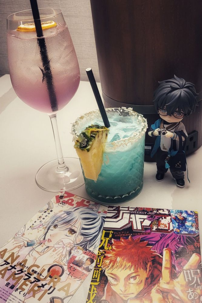 Photo of Dan Heng nendoroid doll with a blue cocktail drink