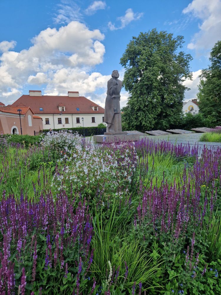 Purple flowers and stone statue