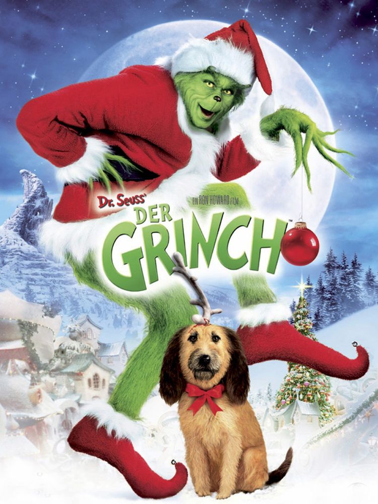 Der grüne Grinch in einem Weihnachtmannkostüm mit seinem Hund mit roter Schleife und Ast auf dem Kopf.