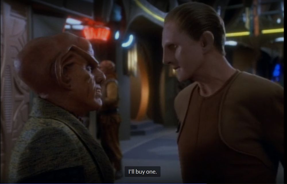 A Ferengi named Quark(Big Ears, orange, with sharp teeths. Wearing some sort of Green multi-piece pajamas) And Odo(Smooth faced, can change shape. Wearing a Dark brown with Light Brown at the shoulder area uniform that also looks like a Pajamas). 

Quark and Odo are talking. Odo is saying "I'll buy one" in the context of in case Quark dies, his body will get sold into pieces by other Ferengi. The reason Quark might possibly die is because of Fallit Kot, who has come to kill him because Quark has sold him out to the Romulans for smuggling Romulan Ale