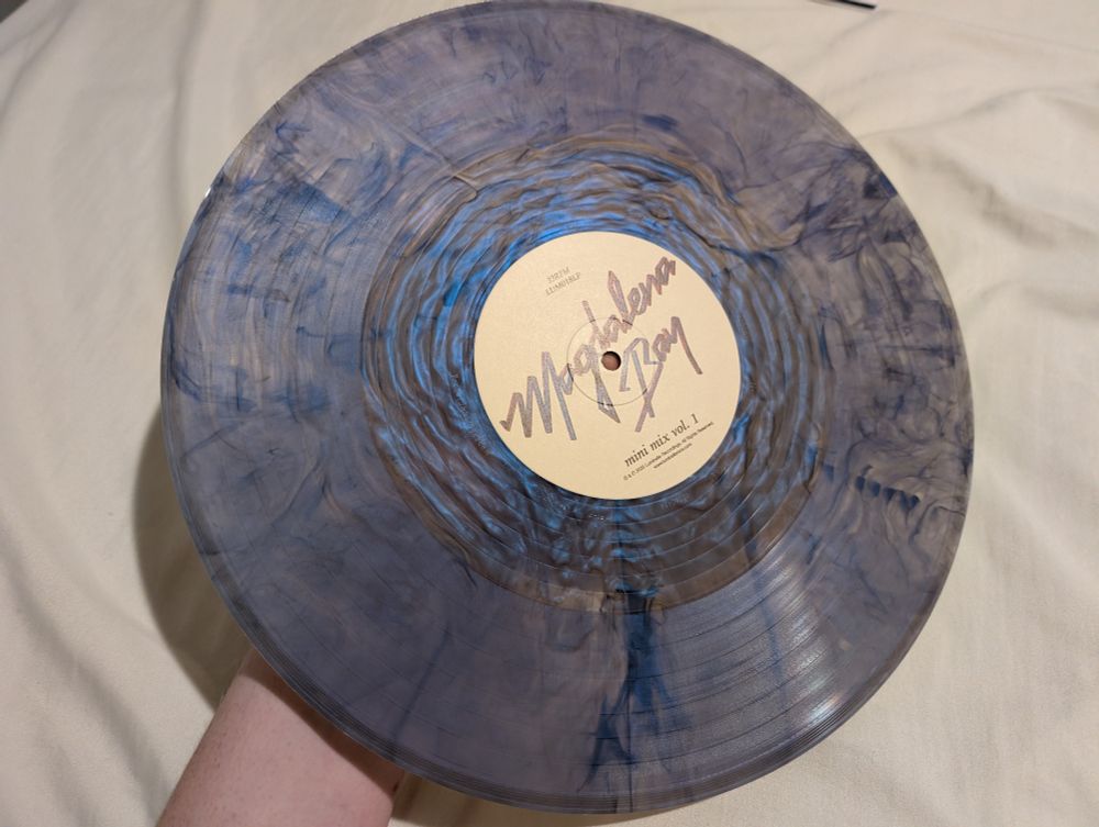 A vinyl record with dark blue, iridescent colors rippling from the center.
