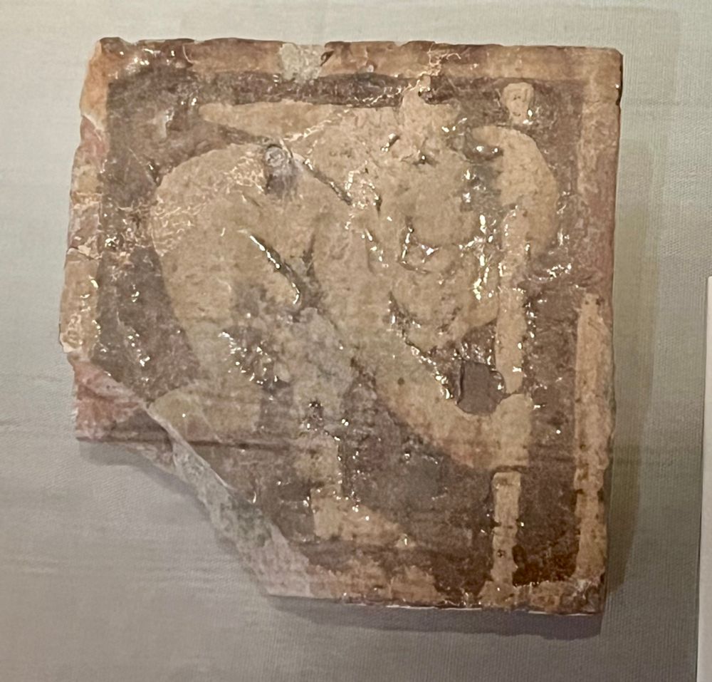 A medieval floor tile with a representation of a pilgrim with a staff 