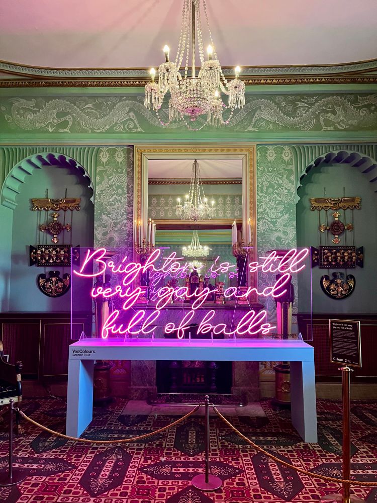 Installation in Brighton Pavilion - neon lights in an ornately decorated room. The neon lights read ‘Brighton is still very gay and full of balls’ (an eighteenth century quote from a visitor to the town)
