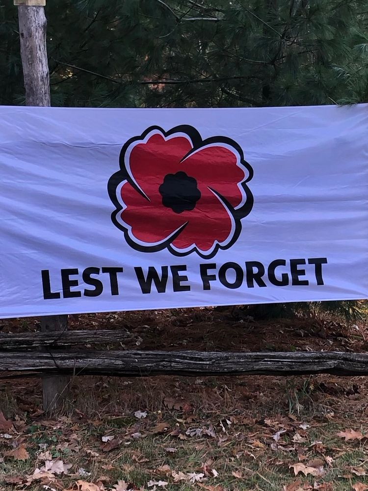 Flag posted at end of laneway with a large poppy and the words ‘lest we forget’ centred underneath.