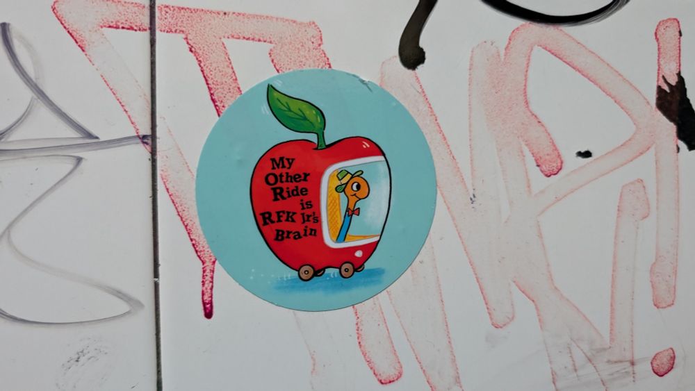 Sicker found in Bryant Lake Bowl mens room. A worm driving an apple that says "my other ride is RFKs brain." 