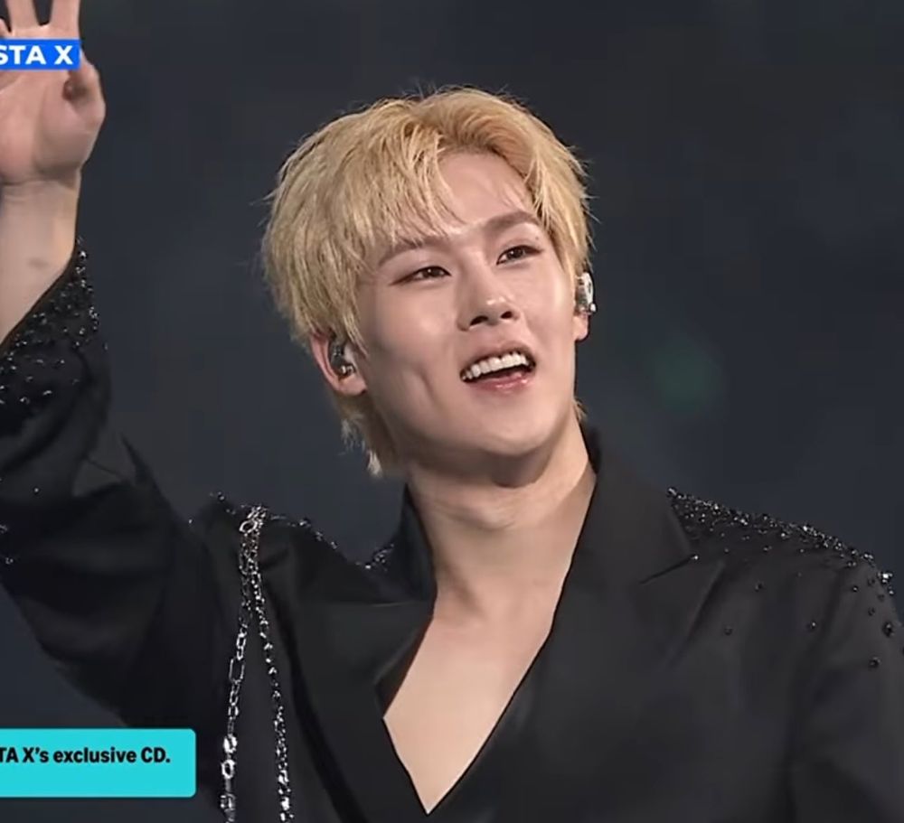 jooheon, blonde, wearing a black blazer while at kcon LA 2025, waving at the people