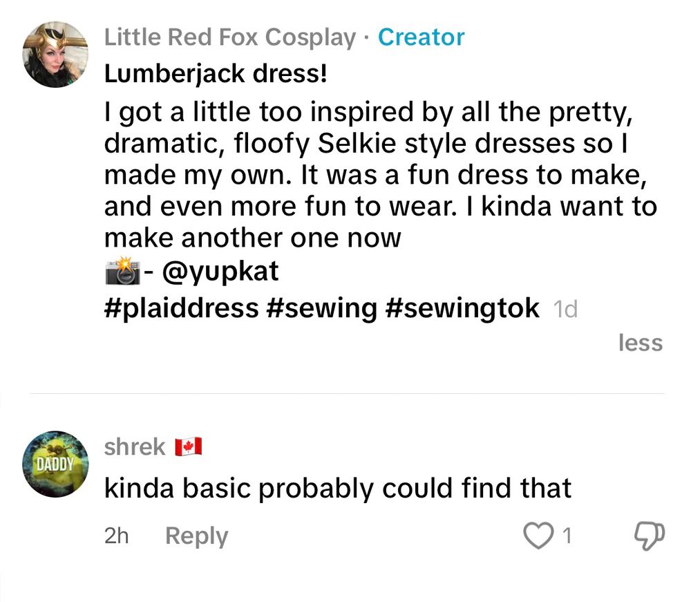 A screenshot of a social media post by “Little Red Fox Cosplay” with the label “Creator.” The post features a comment about a handmade plaid dress, jokingly called a “Lumberjack dress.” The user explains they were inspired by dramatic Selkie-style dresses and had fun making and wearing it. They credit the photographer “@yupkat” and include hashtags like #plaiddress, #sewing, and #sewingtok. Below the post, a user named “shrek” with a Canadian flag emoji comments, “kinda basic probably could find that,” accompanied by one like and a thumbs-down icon.