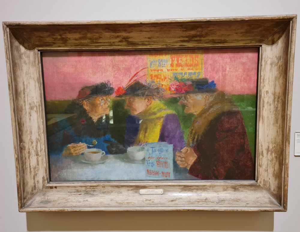 'Les Girls' by James Fitton. 3 older women, huddled around a cafe table, in conversation.