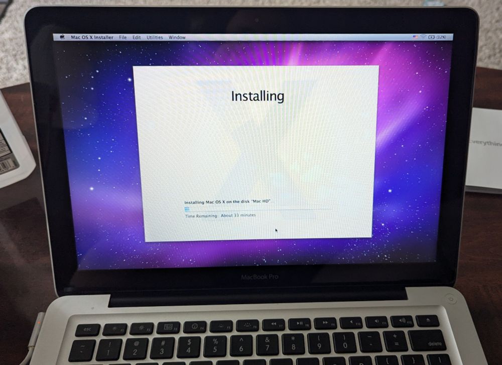 A picture of a MacBook installing OS X with the default space background.