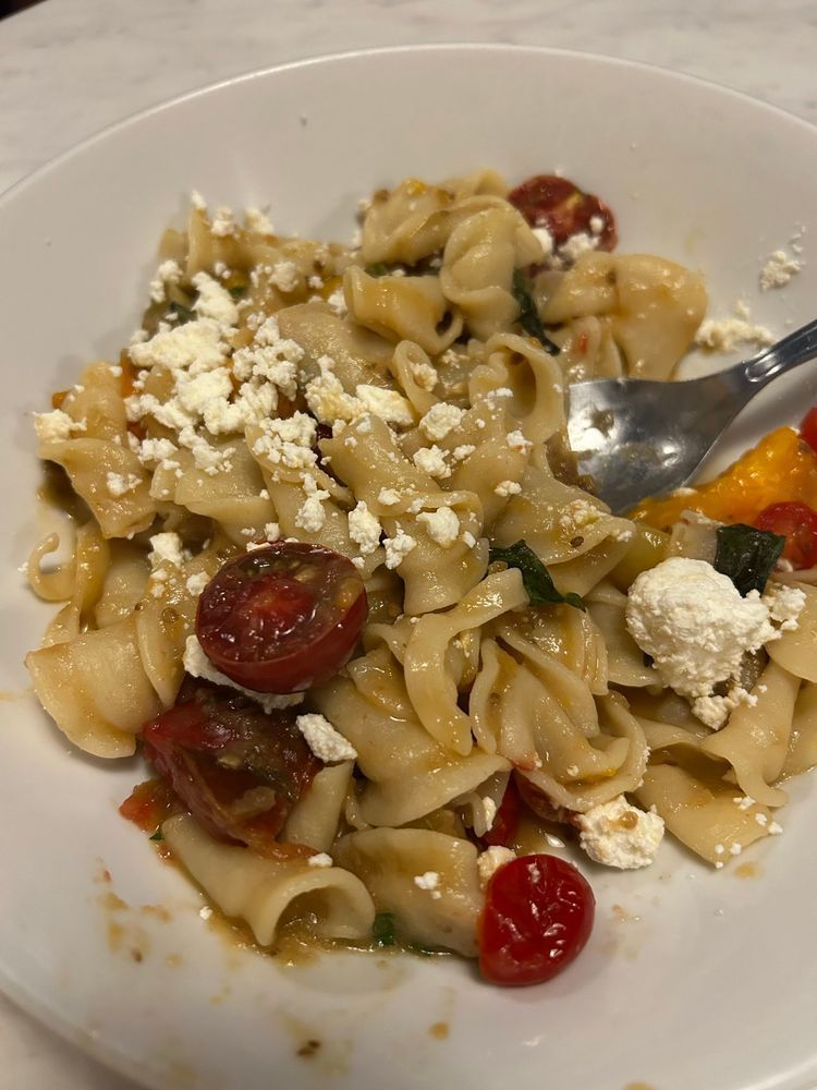 Handmade pasta with fresh summer cherry tomatoes, ricotta, and basil