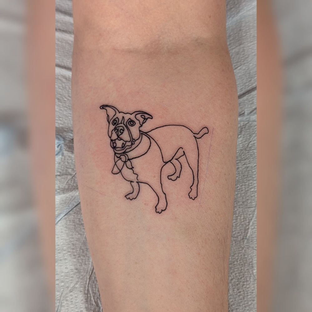 Simple outline of a dog tattooed on a forearm.
