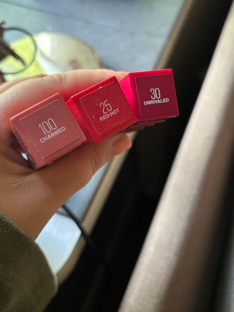 Tre nyanser av läppstift. Ett dämpad rosa/peach. Ett rött. Ett vinrött. 