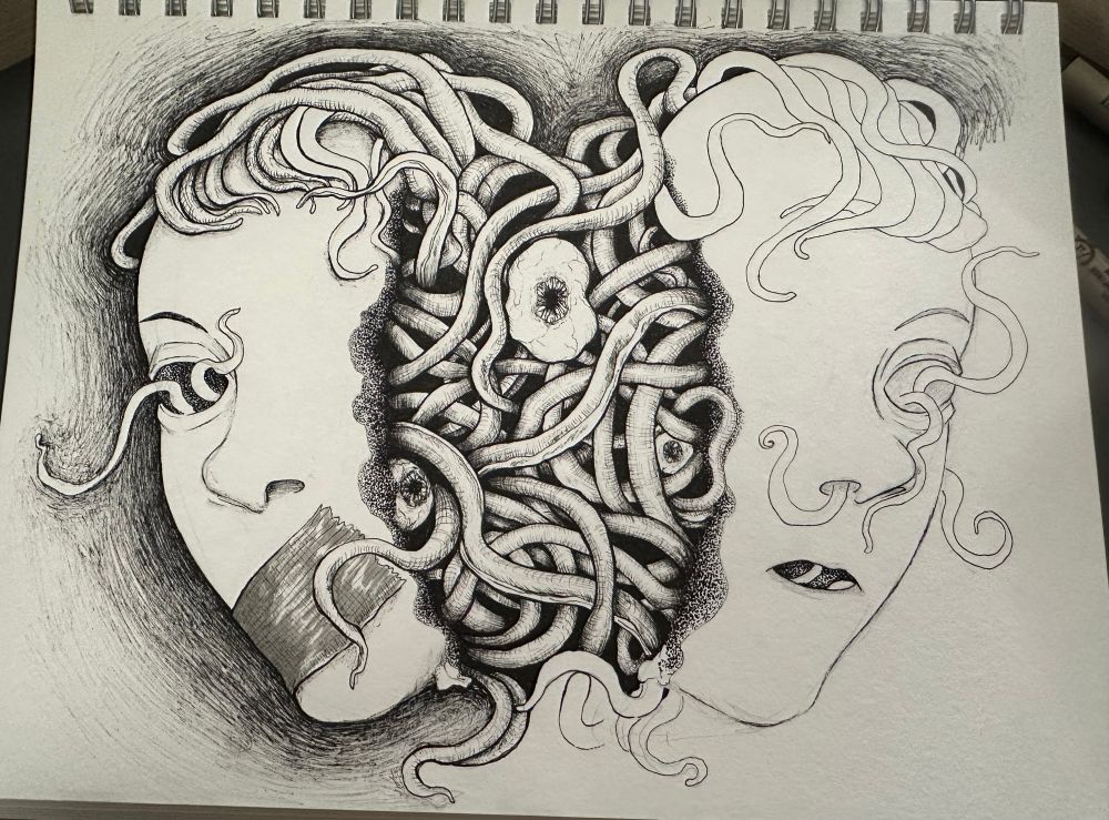 Photo of a sketchbook page with the beginnings of an ink drawing. In the center of the page is a malformed eye, surrounded by a sea of writhing tendrils, with two other eyes hidden within the entwined mass. The tendrils hold two half-broken masks moulded to the face of a young adult on each of its sides. The tendrils create the illusion of a fringe on the top of the face where it holds the masks in place, more tendrils crawling out of the the eye hole on the left mask, and the eye and nose of the right mask. One of the mask’s mouths is gauzed shut while the other remains open. I have finished the line art and have started filling in the black shadows and the stipple that runs across the seam of the broken masks to the mass of tendrils.