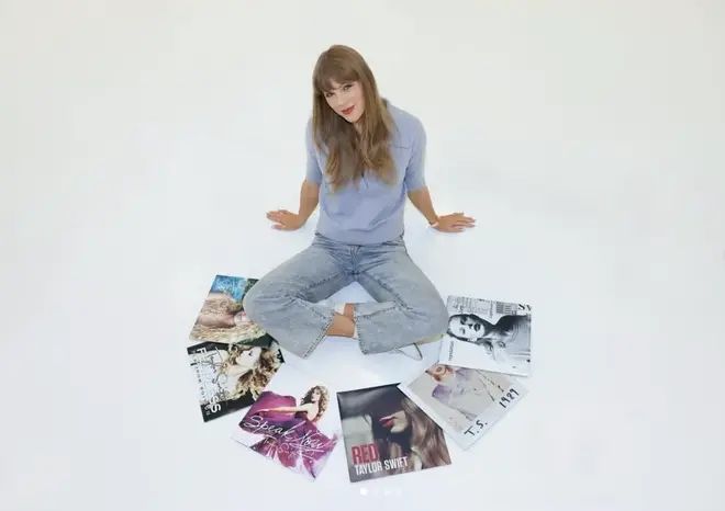 Taylor Swift posing with her first 6 albums