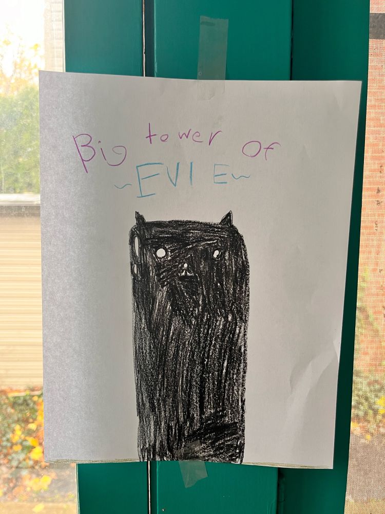 Drawing of a black tower labeled "Big tower of EVIE" taped to a turquoise window.