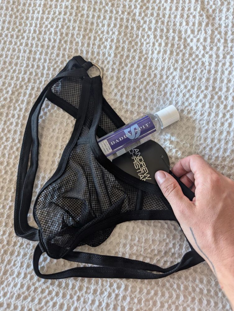 A new gift spread out on Nicola’s bed: black mesh strappy underwear and a small bottle of silicone lube labeled “DADDY’S SPIT”