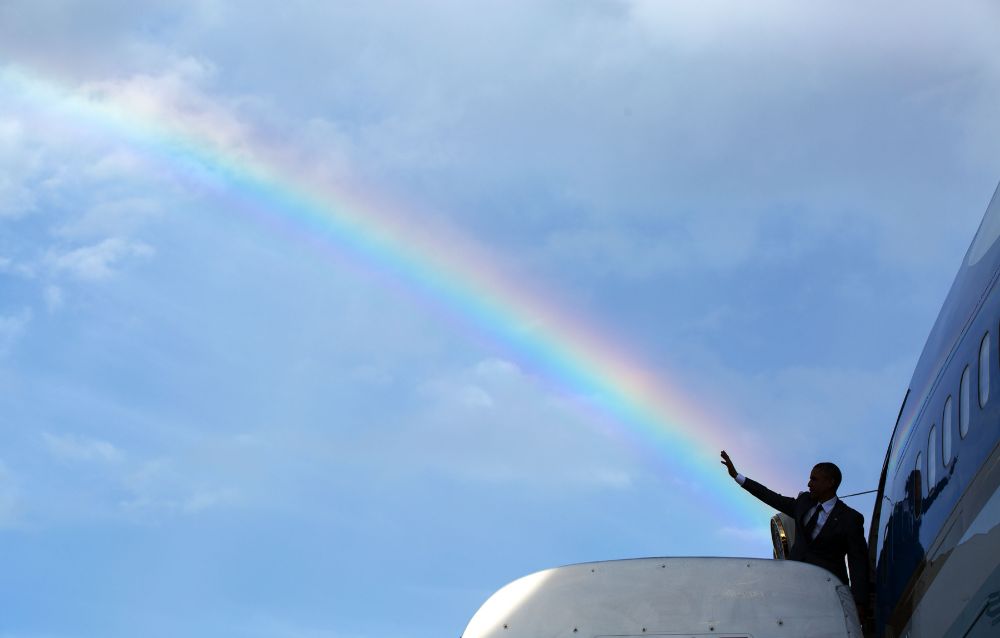 Photo of President Barack Obama boarding Air Force One in Jamaica, beaming a rainbow from his hand like the badass that he is