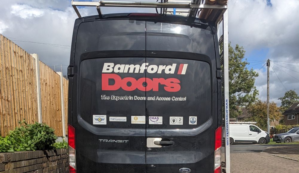 The back of a black van with white and red writing on it stating the company name, Bamford Doors.

Apologies for the terrible joke above.