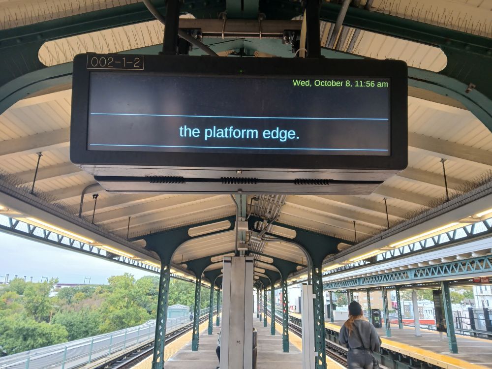 A digital subway sign that simply says "the platform edge" at the bottom. At the top, only the date and time. The missing text (if any) is destined to launch endless speculation, many dissertations, and at least three podcasts.