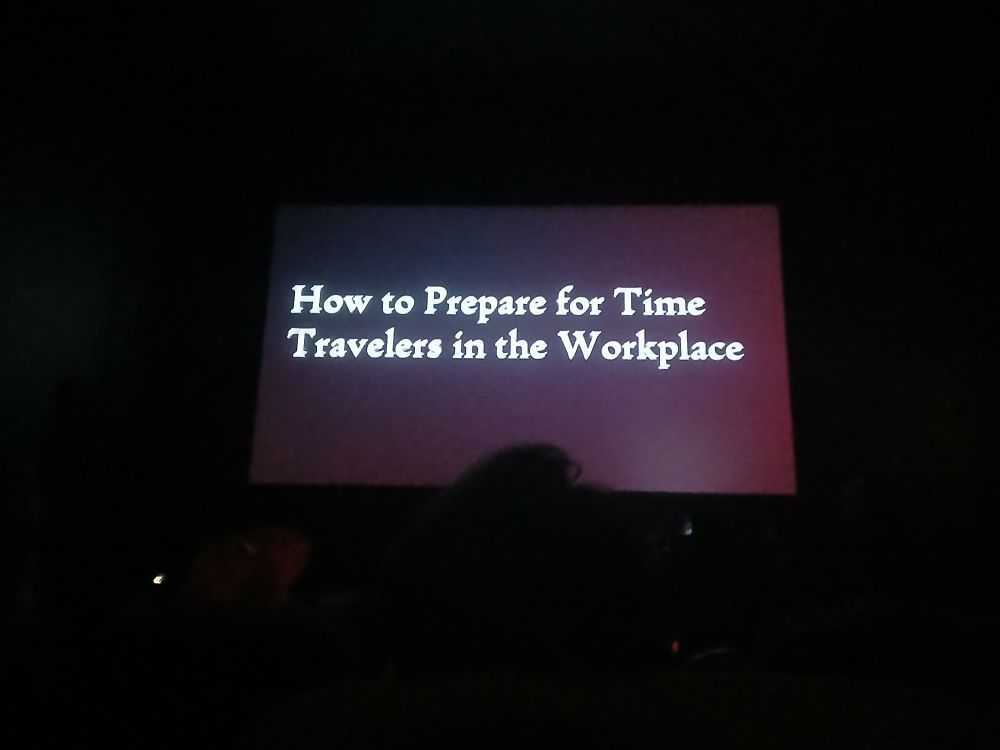 The title card for my film ("How to prepare for time travelers in the workplace") on the big screen in a packed movie theater.