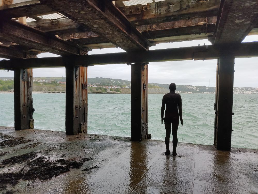 A solitary cast-iron figure, looking out to sea
