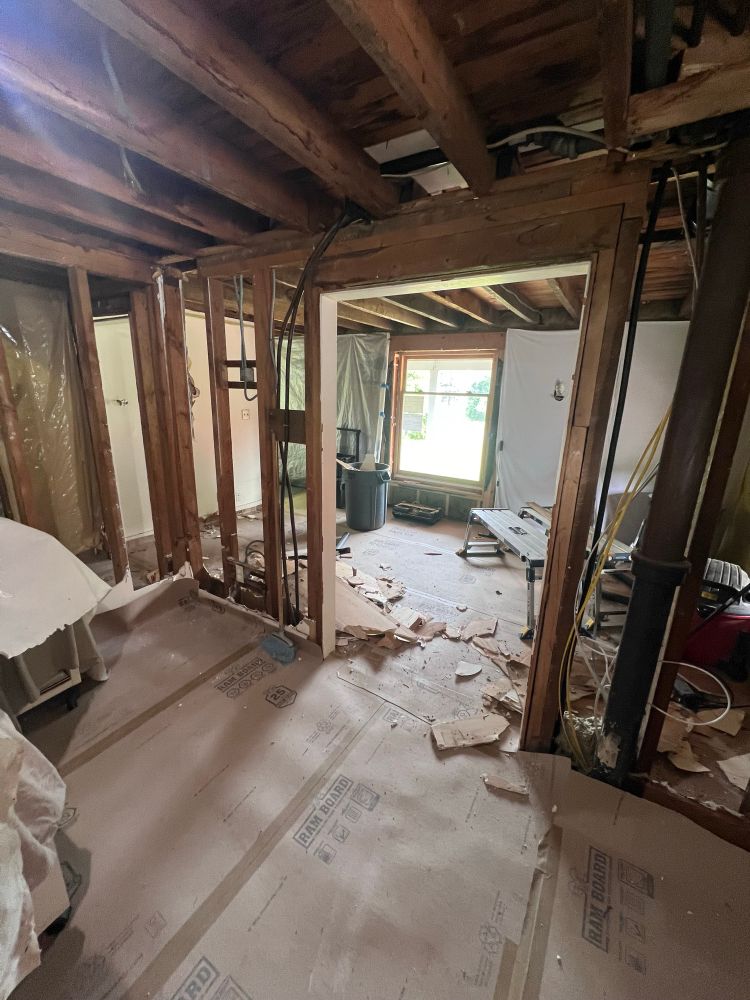 A house interior with demoed ceiling and walls