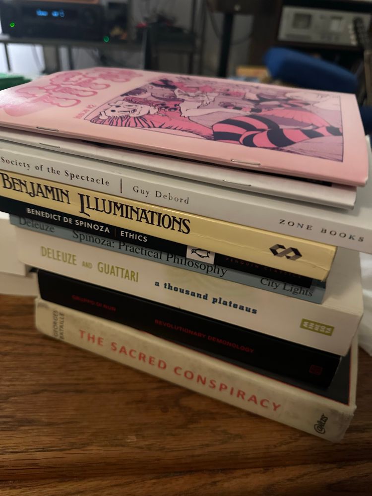 a stack of:

-Yiff zine 1&2
-Society of the Spectacle by Guy Debord
-Illuminations by Walter Benjamin
-Ethics by Baruch Spinoza 
-Spinoza: Practical Philosophy by Gilles Deleuze 
-A Thousand Plateaus by Gilles Deleuze and Felix Guattari
-Revolutionary Demonology by Gruppo di Nun
-The Sacred Conspiracy by George Bataille et al.  