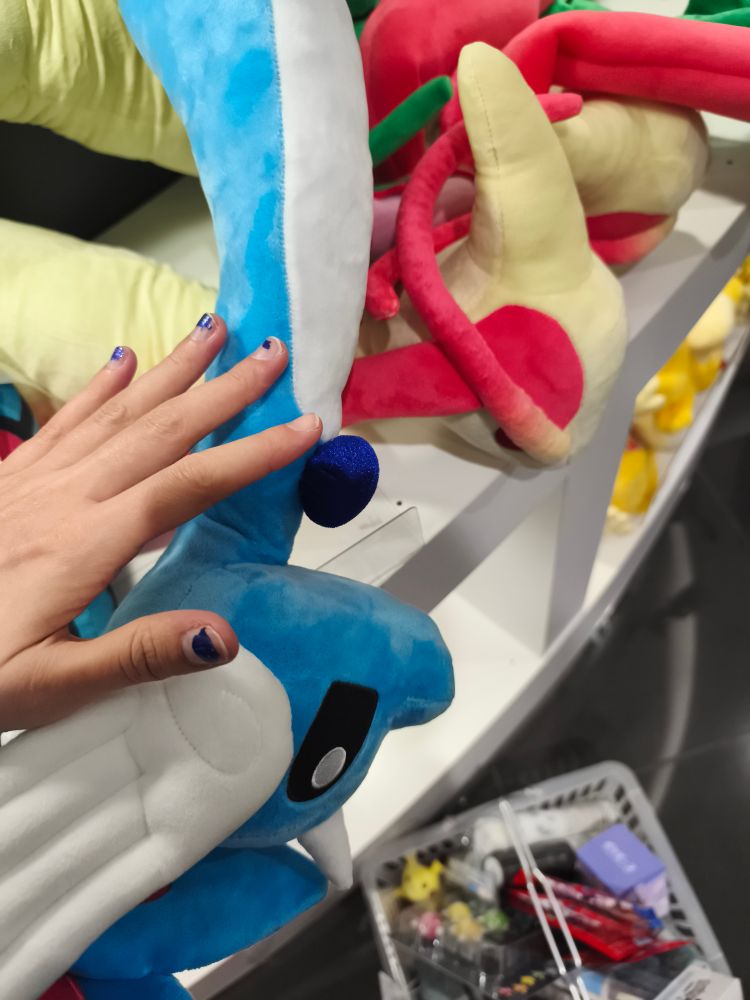 Zoom on a Dragonair plushie with my hand for scale: its head alone is about the size of my hand. They big.