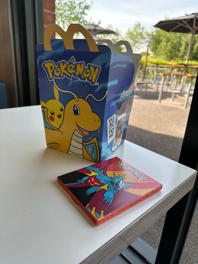 McDonald’s happy meal box with the Pokémon toy by its side.