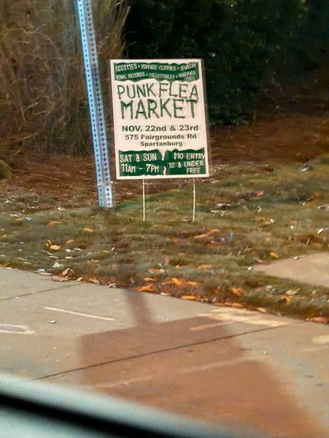 Roadside sign advertising a "Punk Flea Market" on Nov. 22nd and 23rd in Spartanburg, SC.