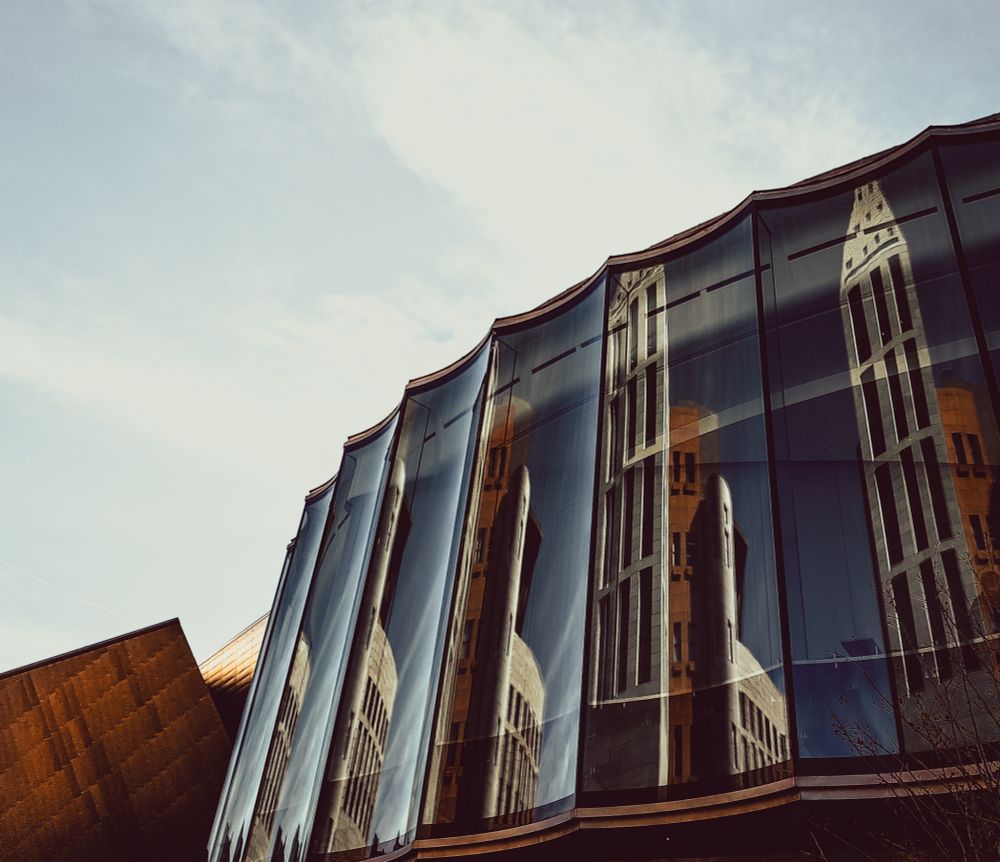 Denver Central Library reflected in the glass of the Denver Art Museum.