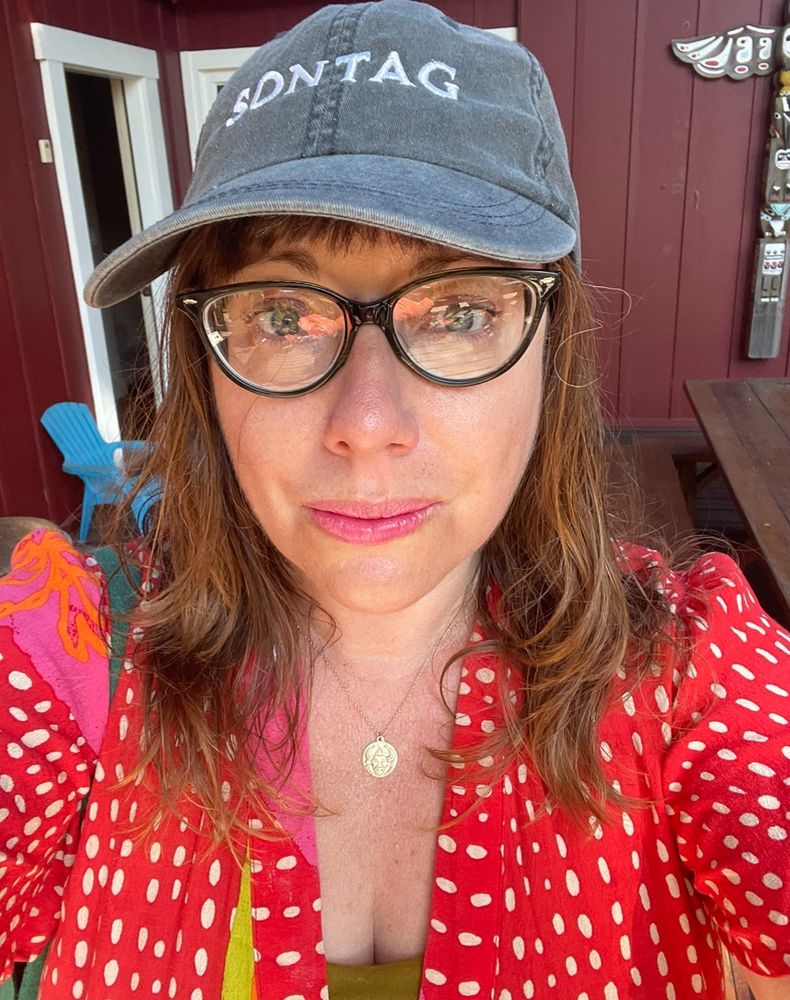 Me with way more white hair, not smiling and wearing glasses because I forgot my contact solution while sporting a Sontag hat 