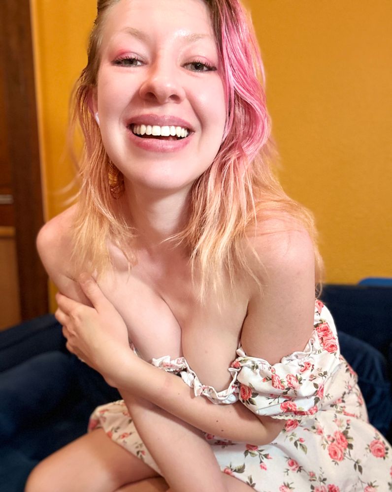 Valentine leaning over showing off cleavage in a white floral sun dress 