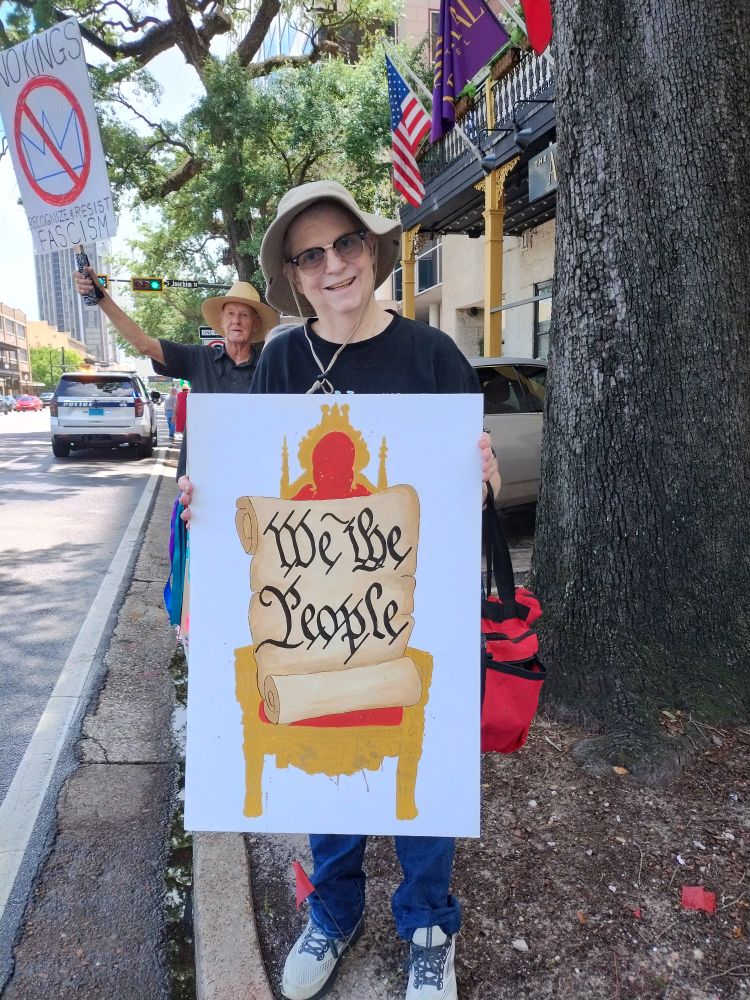 Woman holding a "We the People" sign at the Mobile, AL No Kings/Indivisible protest June 14, 2025