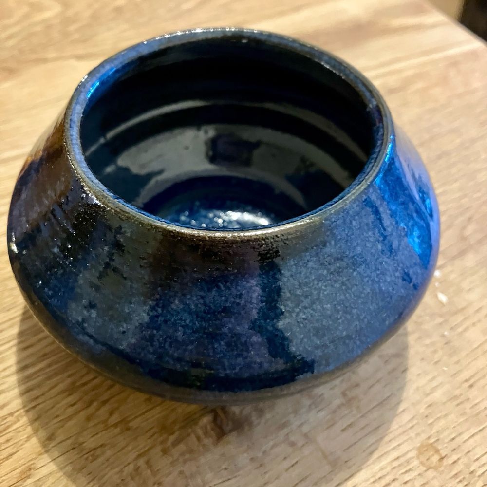 A little blue ceramic pot with a big fat belly.