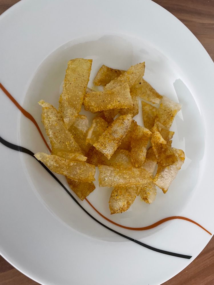 Ein Teller voll selbstgemachter Chips aus Reispapier. Goldgelb geröstet.