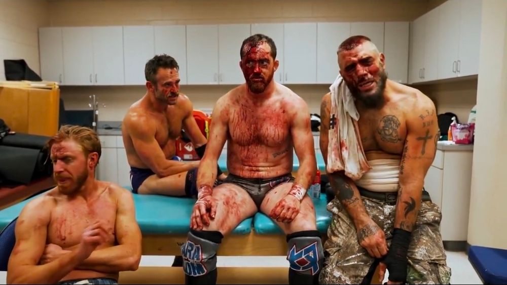 Freshly Squeezed Orange Cassidy, Roderick Roddy Strong, Kyle O'Reilly, and Mark Briscoe, beaten, bloody, and bruised, following their win at AEW Dynamite Blood and Guts