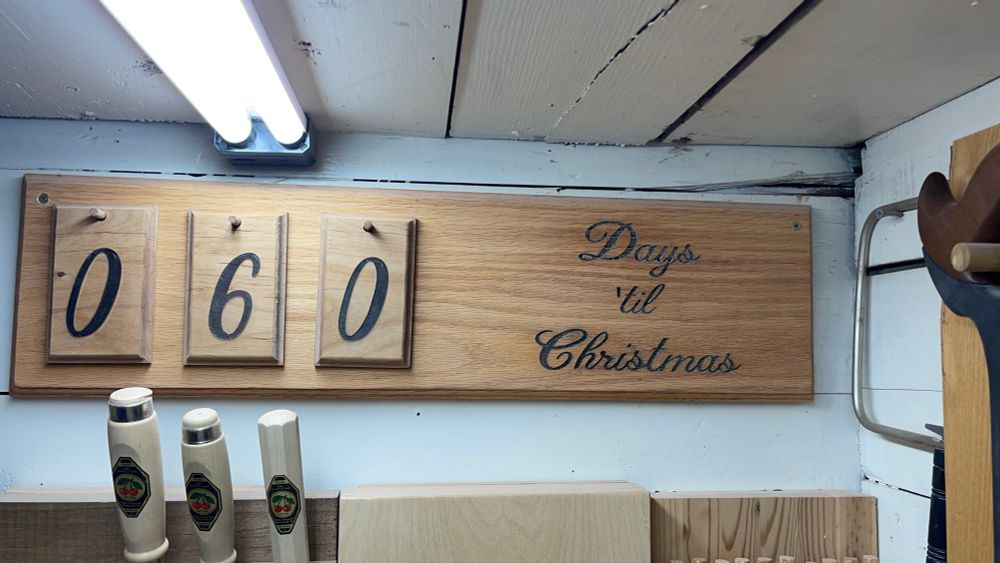 Wooden shop sign reading “060 Days ‘til Christmas”