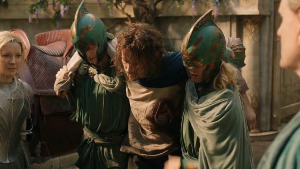 Halbrand being carried by two elves 